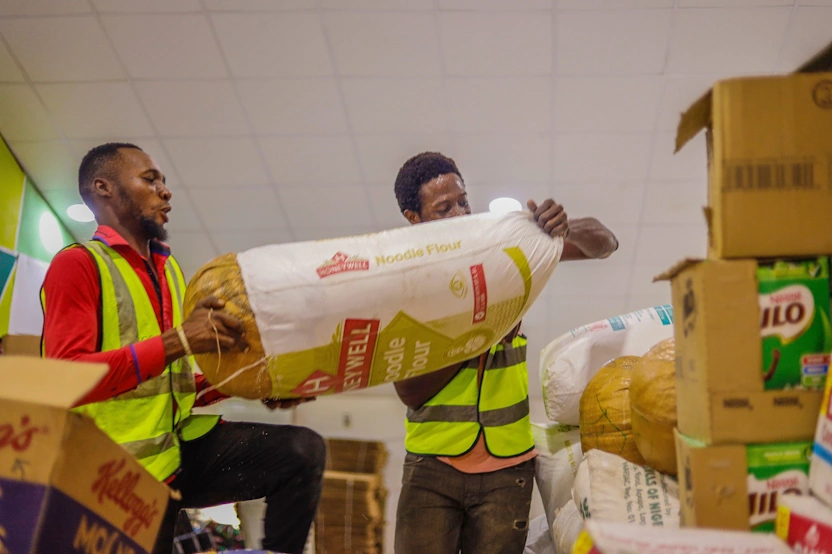 two persons helping each other to put a sack in the right side